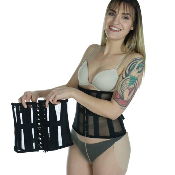 Model wearing mesh waist trainer, smiling, holding up another waist trainer.